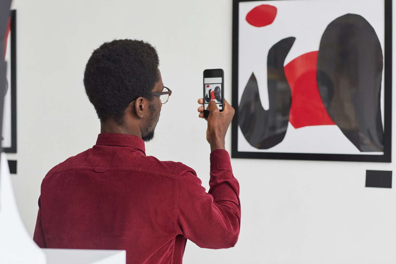 African-American Man Recording Video in Modern Art Museum